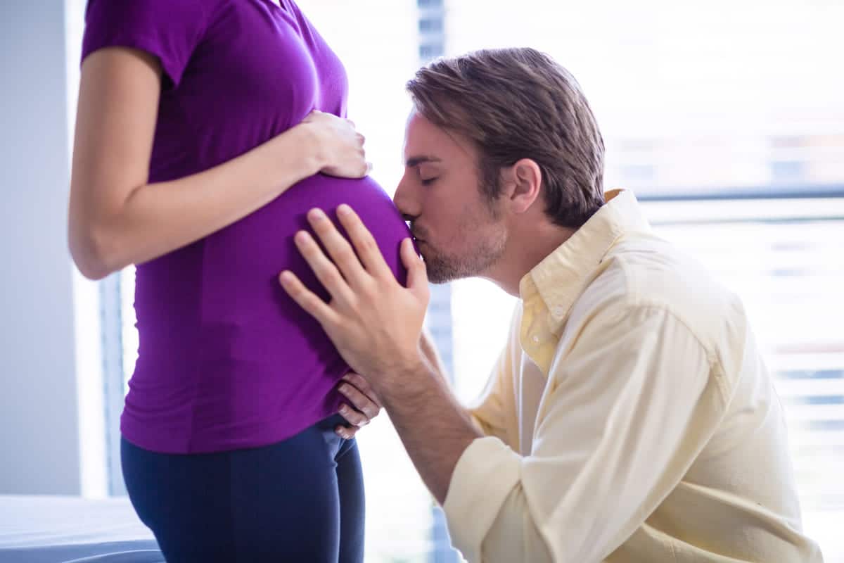 man kissing pregnant womans belly in ward 2021 08 28 16 44 47 utc
