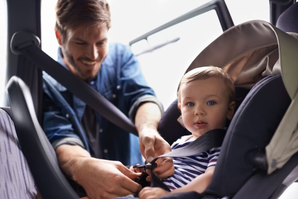 a young father strapping his baby into a car seat 2023 11 27 05 08 37 utc(1)(1)