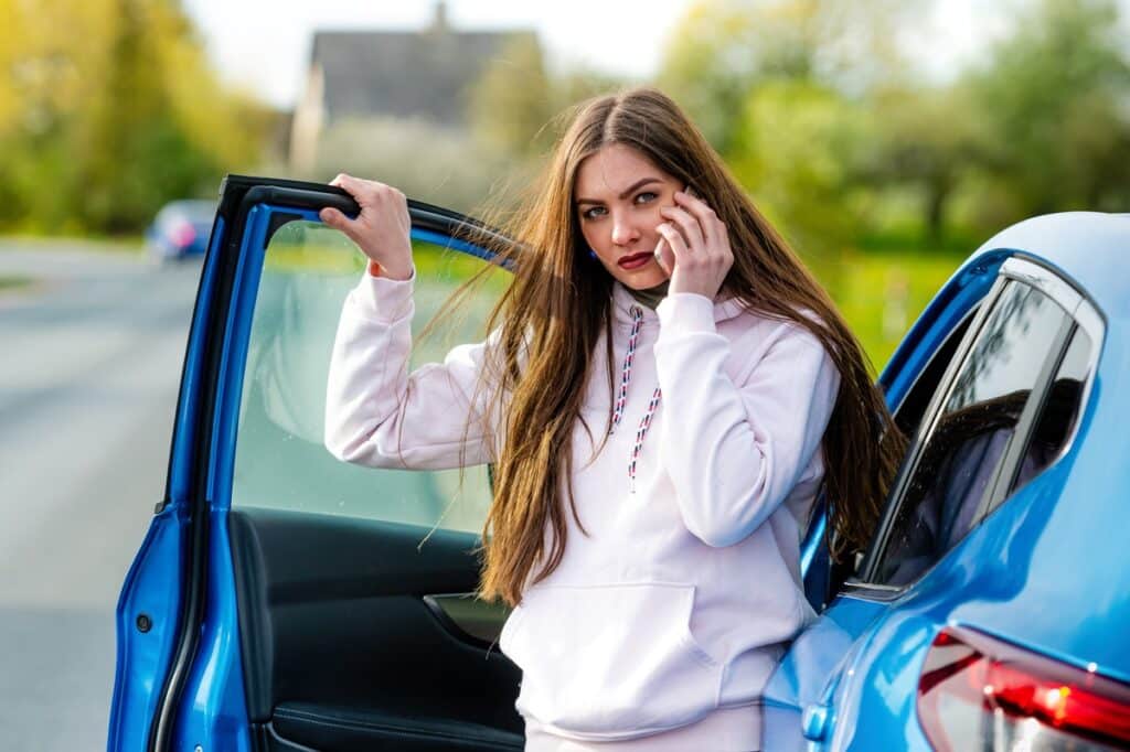 young emotional brunette woman gets out of the car and talks on